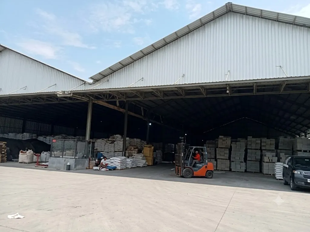 Gudang penyimpanan stok pupuk dengan forklift dan tumpukan karung